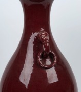 A Chinese Sang de boeuf&nbsp;porcelain vase with monster&nbsp;mask handles and fixed hanging rings, 19th/20th century, note: Restoration to rim. ​​​​​​​59cm high - 2