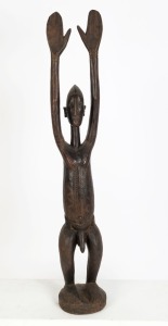 A tribal statue of a man with raised hands, carved wood, West African origin, ​​​​​​​104cm high