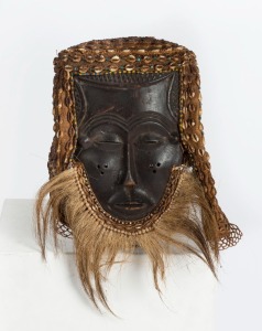 A tribal mask, carved wood, shell, beads, cloth and fibre, Kuba tribe, Central Africa 39cm high