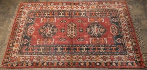 A Persian hand-knotted wool rug with red ground, 216 x 131cm