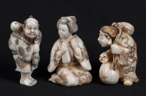 Three Japanese carved ivory netsuke of a man with a child, a Geisha, and a travelling man with a sack, 20th century, ​​​​​​​the largest 5cm high