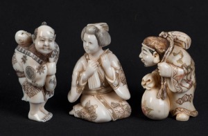 Three Japanese carved ivory netsuke of a man with a child, a Geisha, and a travelling man with a sack, 20th century, the largest 5cm high