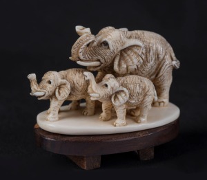 A Japanese carved ivory elephant group netsuke, on later wooden base, 5cm wide