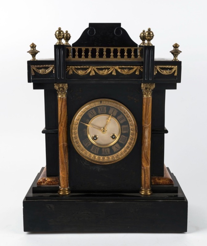 An antique French black slate mantel clock, with variegated marbel corinthian split collums and brass mounts. black slate and guilt roman numeral chapter ring, 8 day time and gong striking movement, circa 1890, 42cm high, 33cm wide, 17cm deep