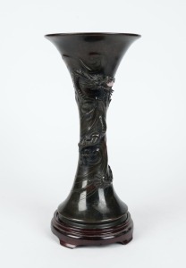 An antique Japanese bronze vase with dragon decoration, on wooden stand, Meiji period, 40cm high