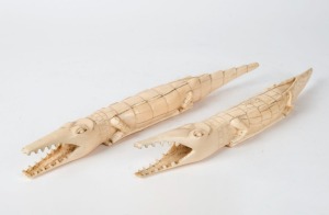 A pair of crocodile ornaments, carved hippopotamus tooth, early 20th century, 30cm and 32cm long