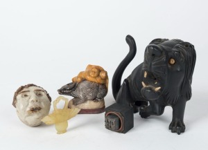 A Chinese carved wooden lion statue, a carved jade basket ornament, a carved stone figural group, a metal seal, and a pottery whistle, (5 items), the largest 11cm high