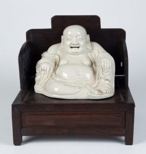 A Chinese blanc de chine porcelain statue of Buddha, seated on a Chinese timber throne, 19th and 20th century, the seat 28cm high, 27cm wide, 24cm deep