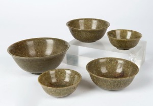 Five assorted Chinese green jade bowls, 19th/20th century, the largest 5cm high, 12.5cm diameter