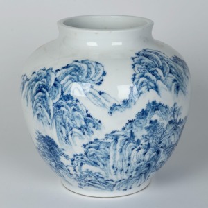 A Japanese blue and white porcelain vase decorated with landscape mountain scene, late Meiji period, 20th century. Made for the Chinese market, four character underglaze mark to base, 24cm high