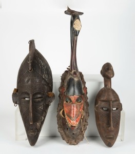 Three tribal masks, carved wood, metal, fibre and paint, African origin, the largest 67cm high