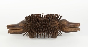 A tribal fetish sculpture in the form of a crocodile, carved wood and metal nails with fibre, West African origin, 42cm long