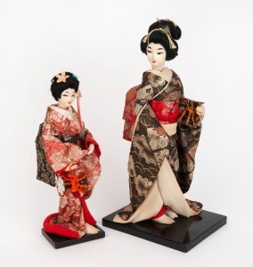 Two Geisha vintage Japanese dolls on black lacquered stands, 20th century, ​​​​​​​37cm and 28cm high