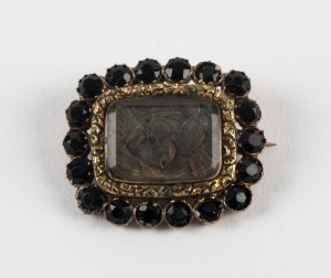 An antique mourning brooch, rose gold and garnet with woven hair window, 19th century, 3.3cm wide