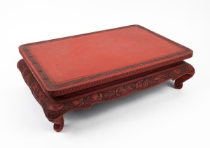 A Chinese red lacquered stand with carved decoration, 19th/20th century, ​​​​​​​15cm high, 52cm wide, 35cm deep