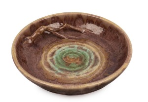 REMUED pottery bowl with applied branch handle, glazed in mauve brown and green, incised "REMUED 1991 LH", 28cm diameter