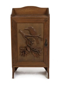 An Australian kauri pine folk art cabinet carved with kookaburra and gum branch, early 20th century, interior fitted with shelves 85cm high x 42 cm wide x 20cm deep