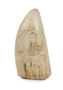 A scrimshaw whale's tooth with portrait of MATTHEW FLINDERS and map of Australia titled "New Holland New South Wales, 1804", with portrait of Trim the cat on the reverse, 12.5cm high