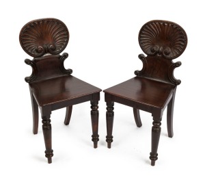 A pair of early Colonial Australian cedar hall chairs with finely carved shell backs and applied roundels, New South Wales origin, circa 1840, 87cm high. PROVENANCE: The Windeyer Family, New South Wales.