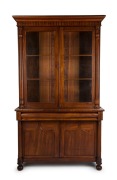 A Colonial Australian cedar bookcase with shield panel doors and turned columns, mid 19th century, 237cm high, 144cm wide, 54cm deep