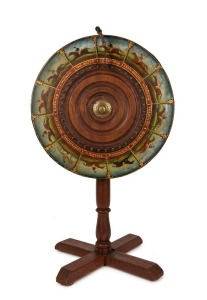AN ANTIQUE AUSTRALIAN HORSE RACING WHEEL-OF-CHANCE A wheel-of-chance depicting twelve different Australian racehorses, painted and titled in oil paint on cedar, the wheel surrounded by brass strapping and mounted on a later stand; the wheel circa 1890. Ov