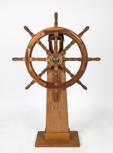 A ship's wheel and wet compass mounted on later timber stand, 20th century, the wheel 92cm wide, 143cm high overall