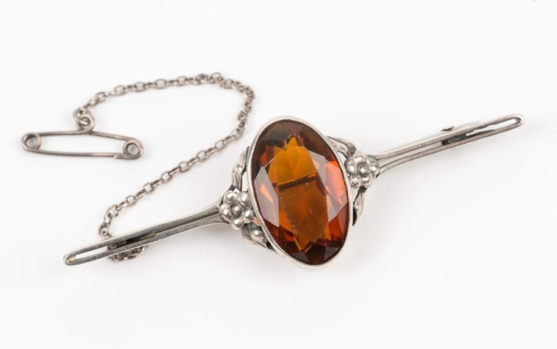 A sterling silver brooch, set with a cut amber coloured stone, early 20th century, ​​​​​​​5,5cm wide