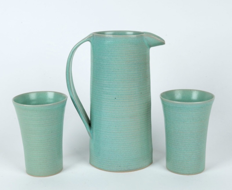 CHRIS SANDERS studio pottery jug and two beakers with sage green glaze, (3 items), impressed "C.S.", with additional signature, the jug 22cm high