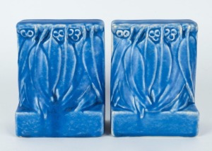 MELROSE WARE pair of bookends adorned with gumnuts and leaves with rare blue glaze, both bearing original paper labels, 14cm high