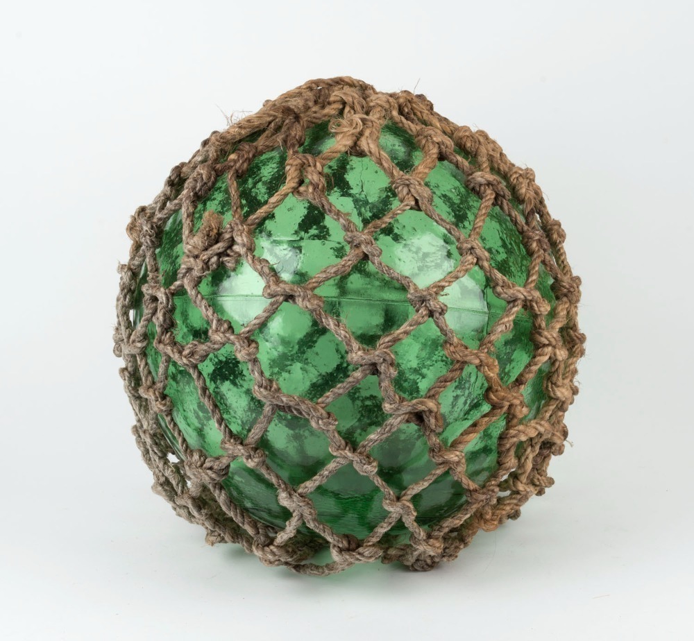 A vintage green glass fishing buoy with rope netting, 20th century