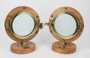 A pair of vintage circular portholes mounted on wooden stands, 20th century, 39cm high