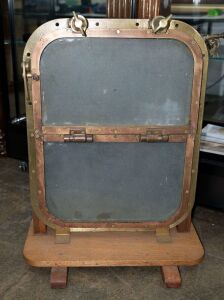 SYGNA ship's porthole hinged window, cast brass with two glass panes, 20th century, mounted on later wooden stand, 81cm high, 54cm wide