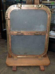 SYGNA ship's porthole hinged window, cast brass with two glass panes, 20th century, mounted on later wooden stand, 81cm high, 54cm wide