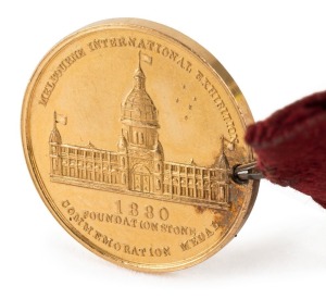 1880 MELBOURNE INTERNATIONAL EXHIBITION, Foundation Stone, commemoration medal in gold (22mm, 8.1g) by (E.Altmann), inscribed on reverse 'H. Creswick Esq. / Commissioner / 19/2/79'  with original button-hole ribbon with button.