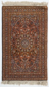 A small Persian hand-knotted wool rug with orange ground, 135 x 77cm