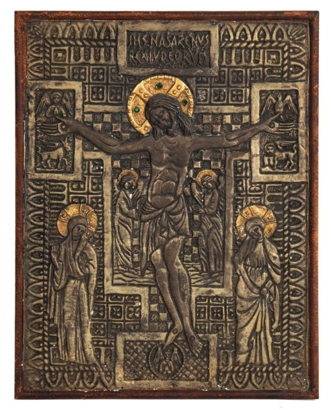 A holy image of the Crucifixion in a Romanesque style, repousse metal encrusted with green rhinestones mounted on leather covered board, 20th century, 42 x 32cm