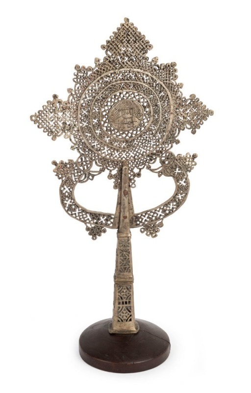 An Ethiopian Orthodox processional cross, bronze with silver finish, 19th/20th century, mounted on later timber stand, 55cm high overall