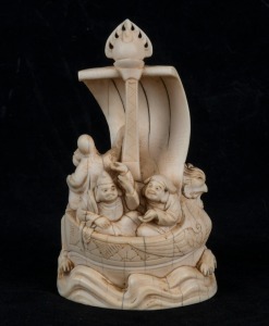 A Chinese carved ivory figural group in a boat, 19th/20th century, carved seal mark to base, 12.5cm high