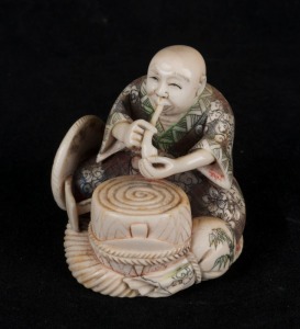 A Japanese carved ivory statue of a seated figure with pipe, Meiji period, 20th century, ​​​​​​​seal mark and signature to base, 6cm high