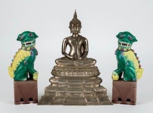 A Thai seated Buddha statue, cast metal with silvered finish, 20th century, together with a pair of Chinese porcelain foo dogs, (3 items), 26.5cm high