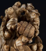 A Japanese carved ivory netsuke figural group of the climbing boys, Meiji period, red seal mark to base, 7.​​​​​​​5cm high, 5.5cm wide - 6