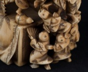 A Japanese carved ivory netsuke figural group of the climbing boys, Meiji period, red seal mark to base, 7.​​​​​​​5cm high, 5.5cm wide - 7