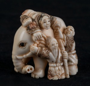 A Japanese carved ivory and hand-coloured netsuke of an elephant and figures, Meiji period, 20th century, 4cm high