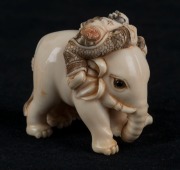 A Japanese carved ivory and hand-coloured netsuke of an elephant and figures, Meiji period, 20th century, ​​​​​​​4cm high - 2