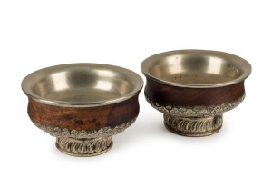 Two Tibetan timber offering bowls with coin silver repousse mounts, 19th/20th century, 6.5cm high, 12cm diameter