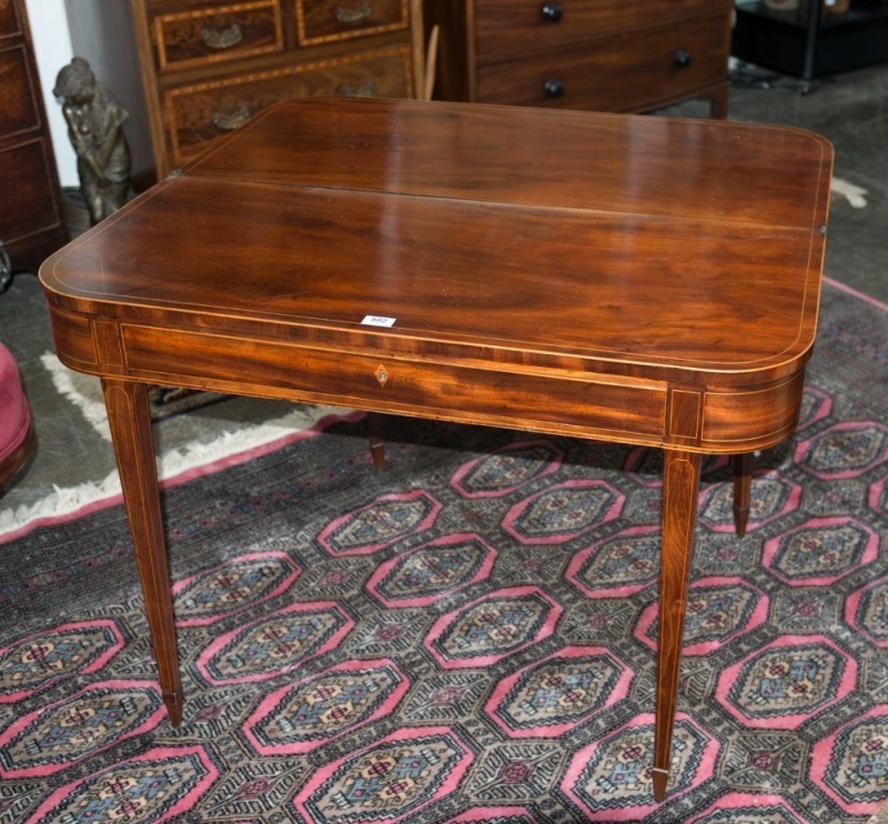 A Georgian mahogany fold-over tea table with square tapering legs and spade feet, early 19th century, 74cm high., by 103cm wide by 45cm deep  