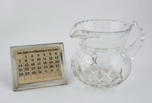 A sterling silver and ivorine desk calendar together with a Grimwade crystal jug, early 20th century, (2 items). the calendar 10cm high