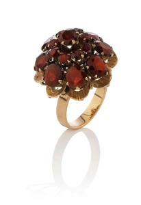 An 18ct yellow gold cocktail ring, set with red stones, stamped "18k", 7.6 grams total
