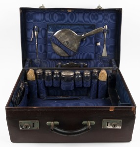 A vintage travel case fitted with sterling silver topped jars and vanity ware, early 20th century, 55cm wide