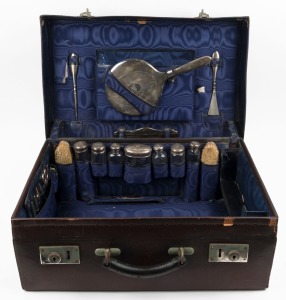 A vintage travel case fitted with sterling silver topped jars and vanity ware, early 20th century, ​​​​​​​55cm wide